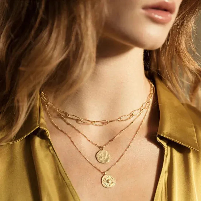 Minimalist and delicate, this necklace feels like a precious ancient vestige. Its hammered full moon design will protect you day and night.