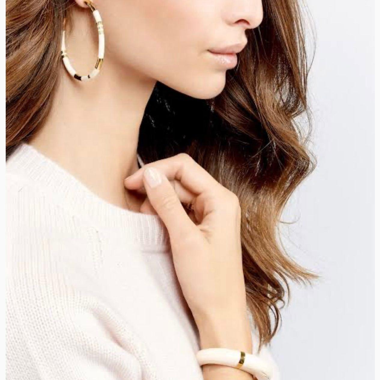 Level up your style with the Aurélie Bidermann Positano Creoles, featuring ivory-colored stripes in resin and gilded with 750/1000 yellow gold.