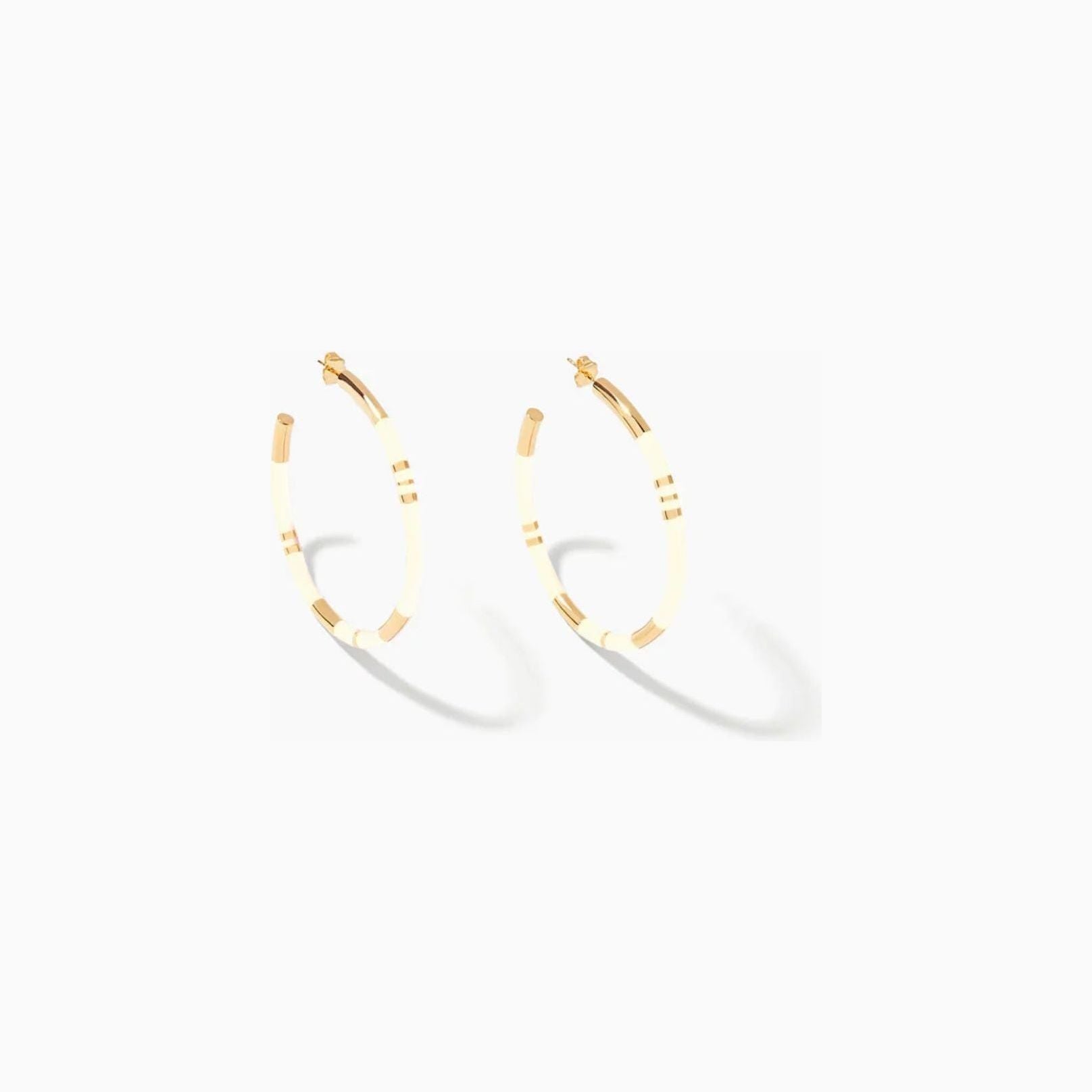 Level up your style with the Aurélie Bidermann Positano Creoles, featuring ivory-colored stripes in resin and gilded with 750/1000 yellow gold.