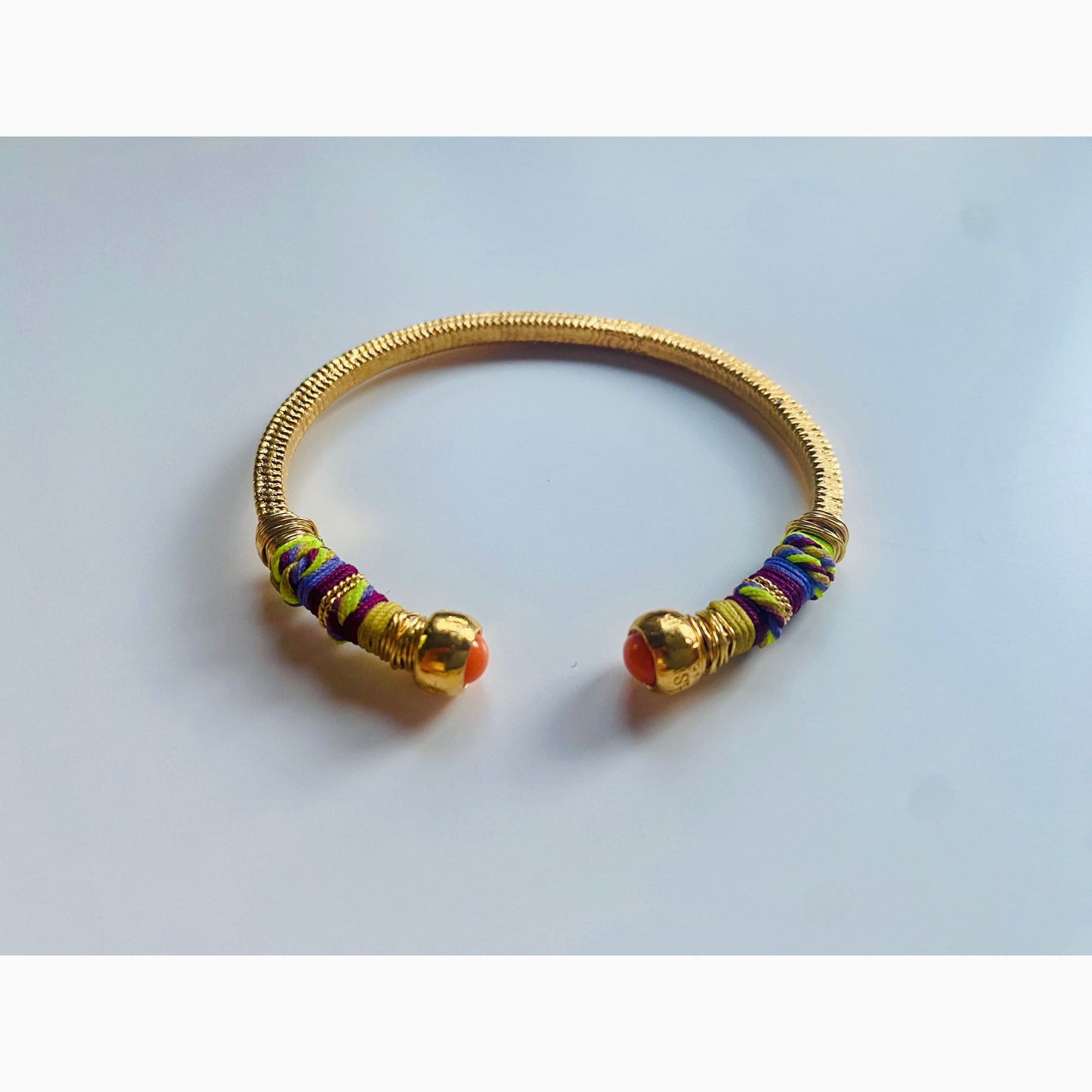 Gold plated bracelet embellished with tinted threads and gold plated chains. The bracelet is adorned with glass beads at ends. Adjustable size. Product Details Yellow Gold Plated Cotton Rope or all metal Width: 0,6 cm; Circumference: 14,5 cm