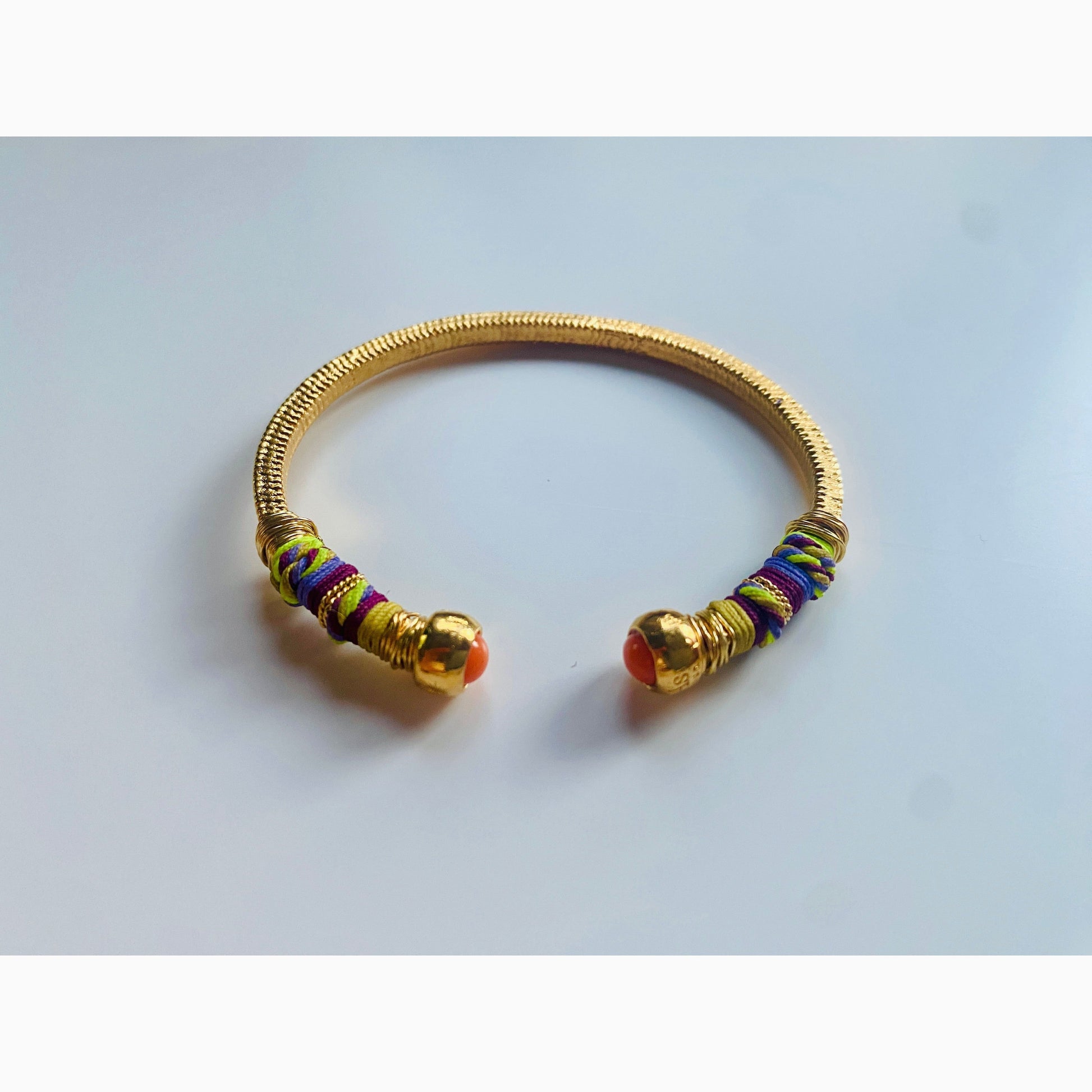 Gold plated bracelet embellished with tinted threads and gold plated chains. The bracelet is adorned with glass beads at ends. Adjustable size. Product Details Yellow Gold Plated Cotton Rope or all metal Width: 0,6 cm; Circumference: 14,5 cm